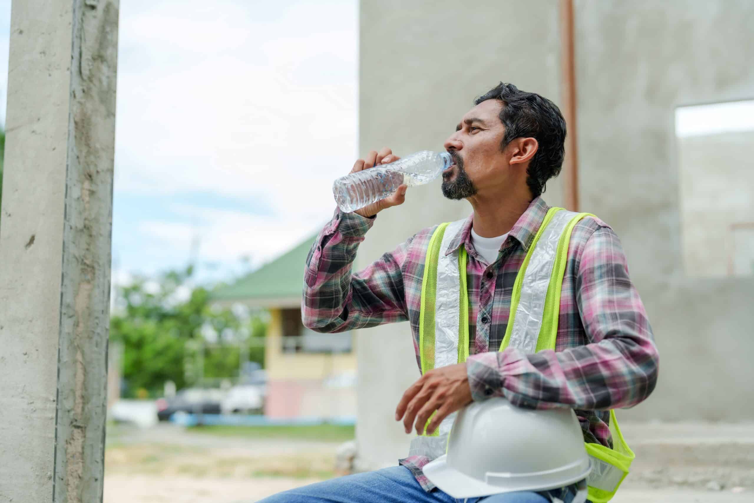 Ein Bauarbeiter trinkt Wasser