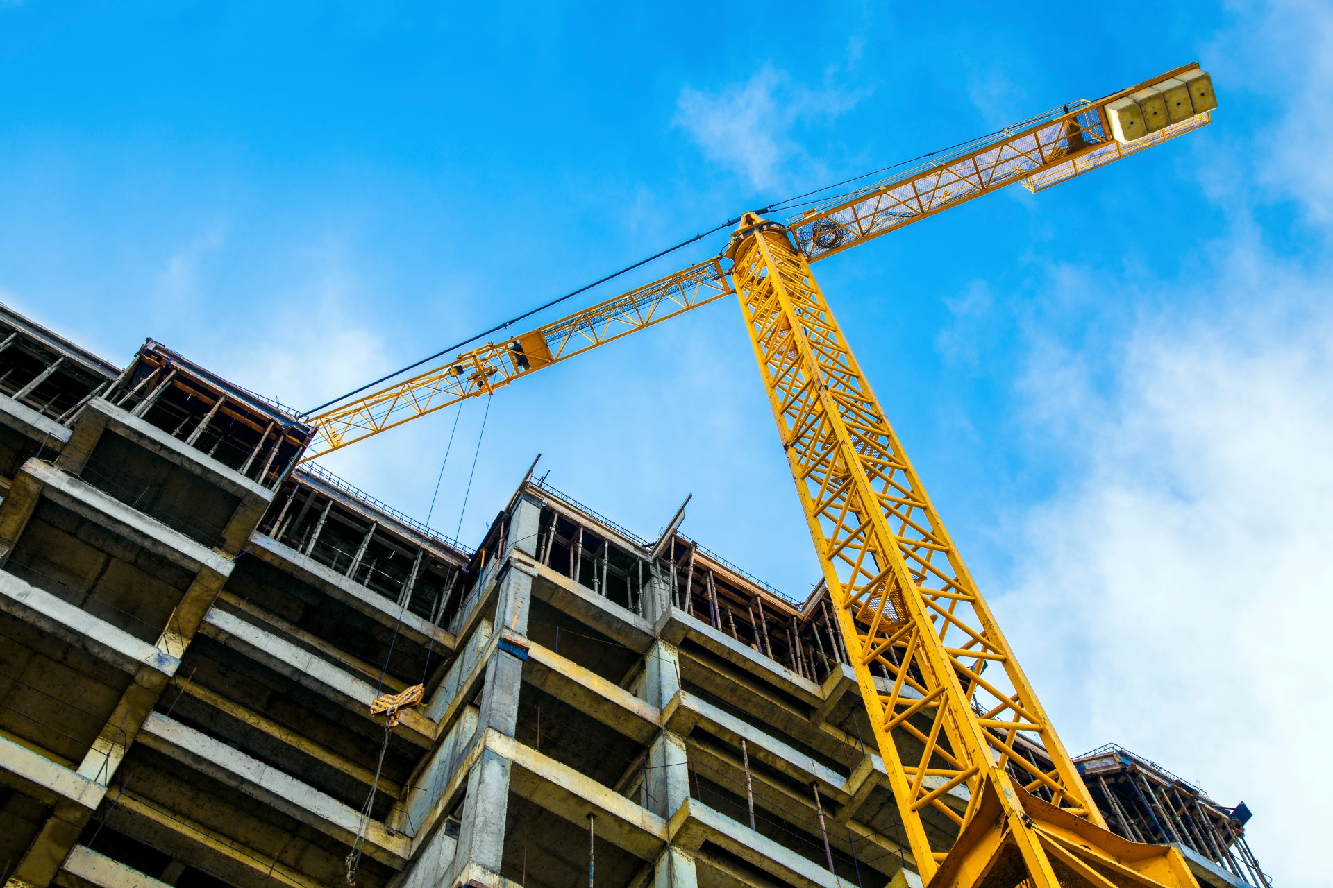 Gelber Kran mit Elektroseilwinde auf Baustelle