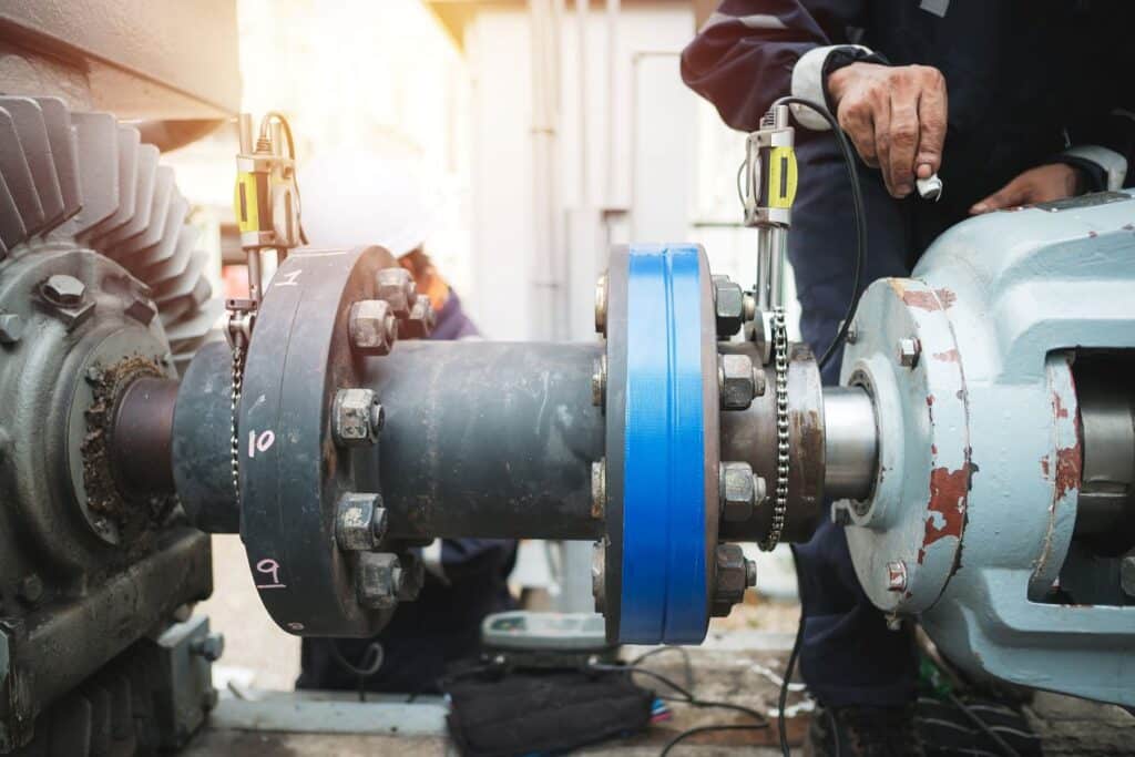 Technician installing hydrogen sensors on industrial machinery, highlighting safety measures in construction and manufacturing