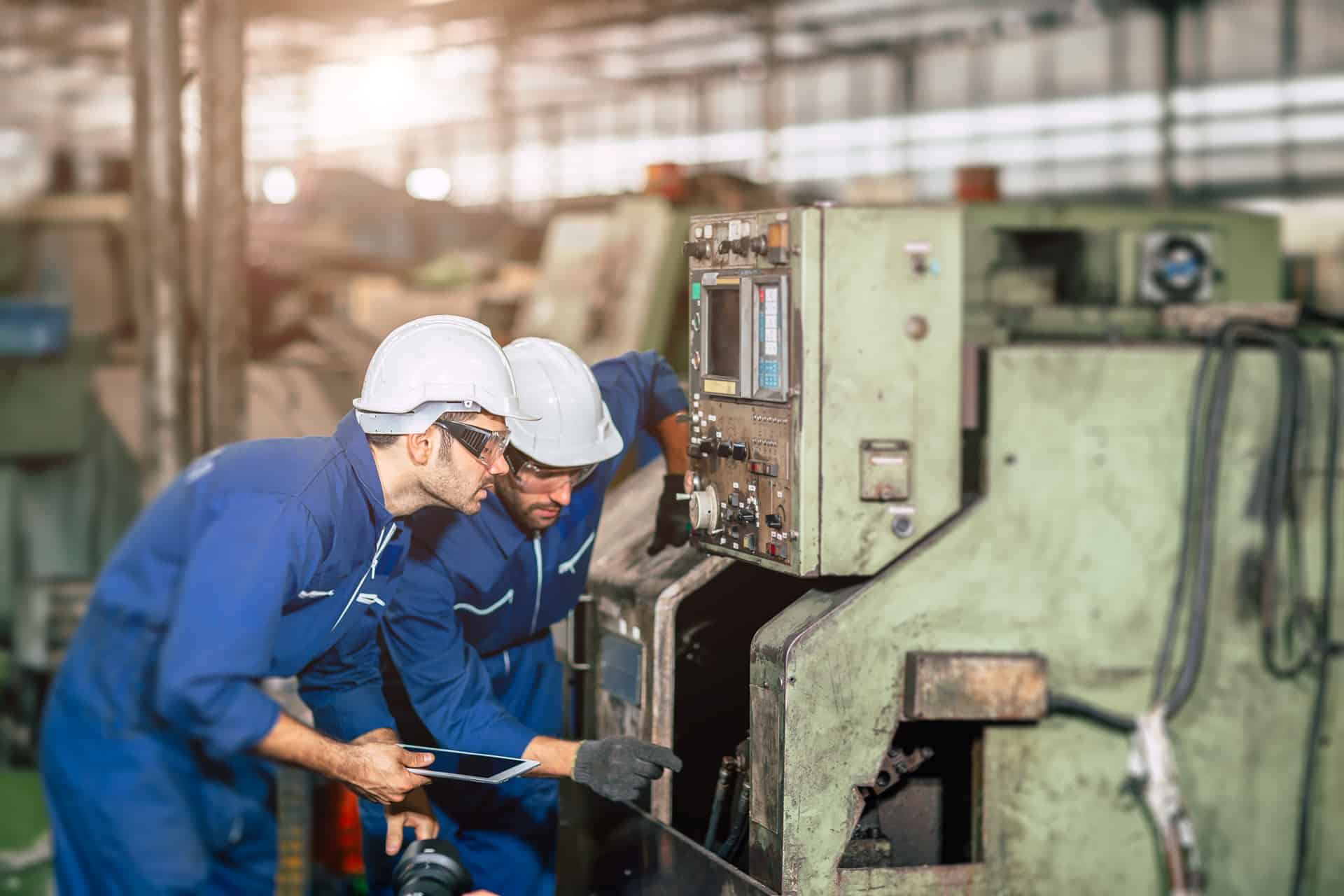Techniker prüfen flexible Schläuche an Industrieanlage