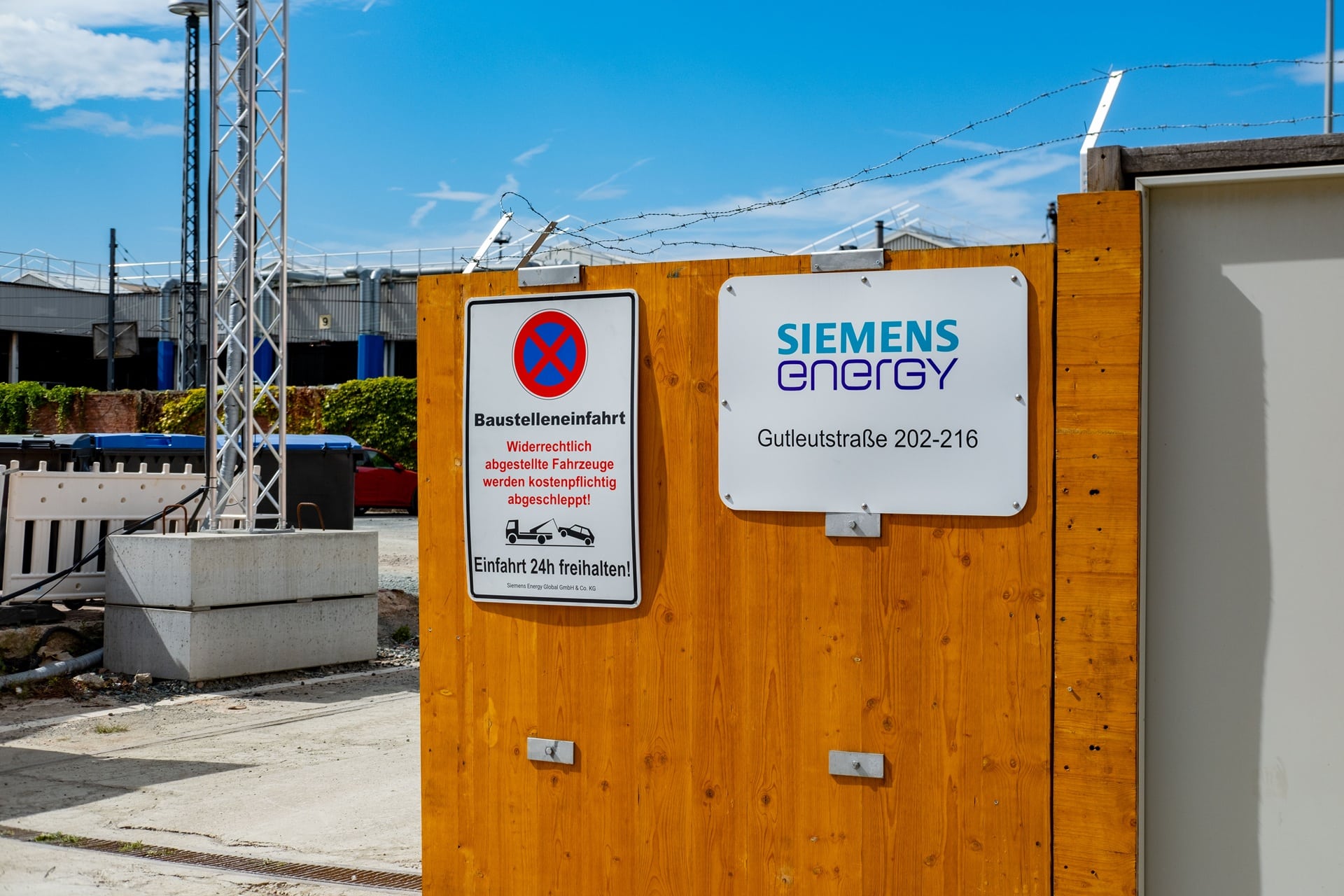 Baustelleneinfahrt mit Schildern und Gerüstbanner
