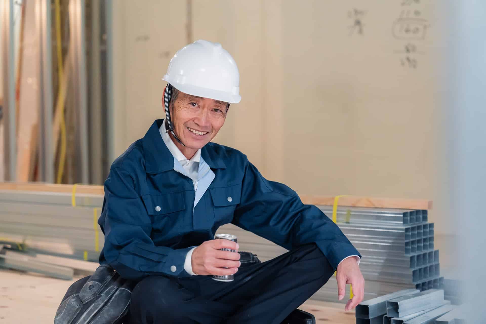 Bauarbeiter sitzt entspannt auf Baustelle mit Getränk | Randm Tornado