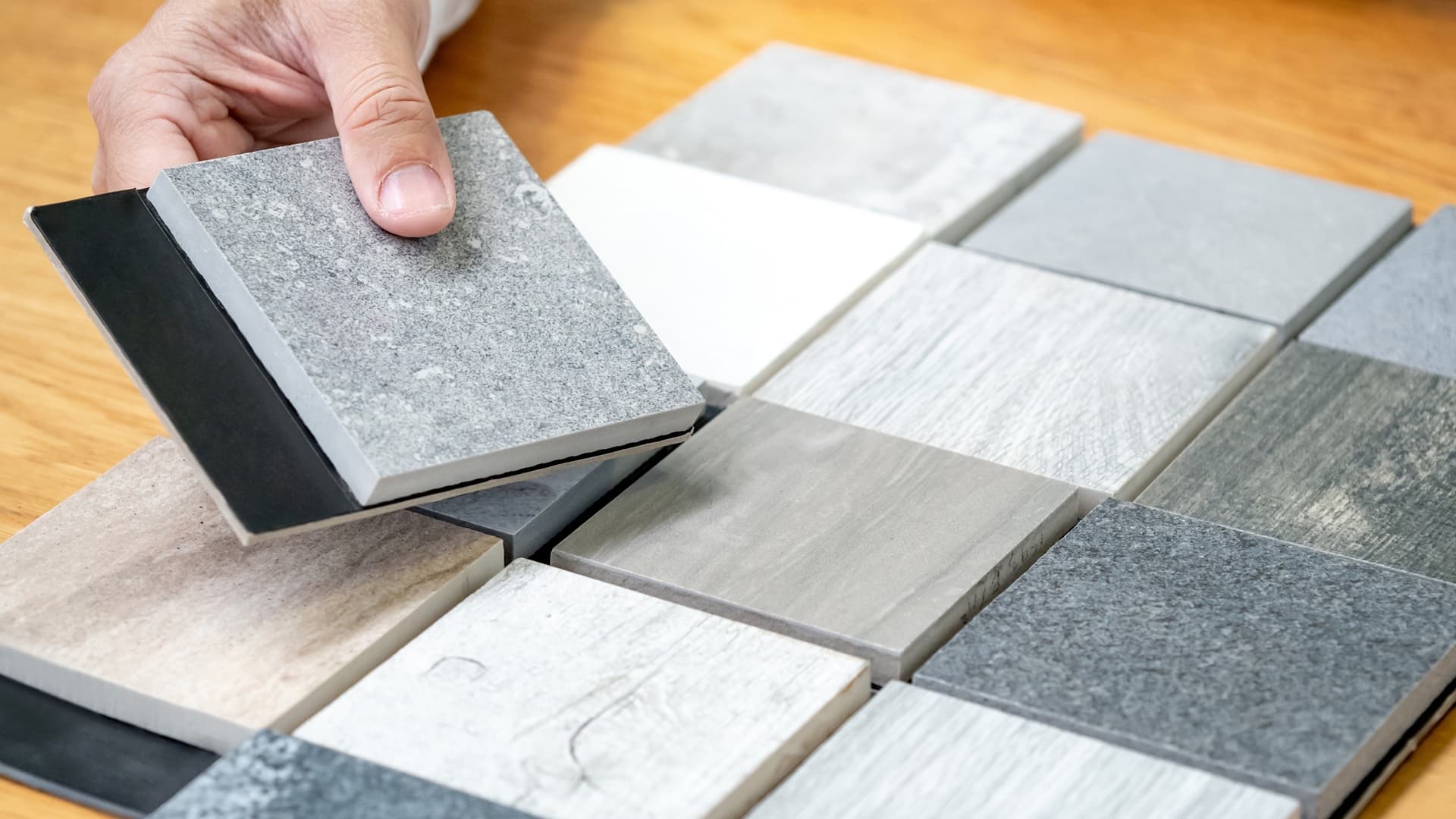 Hand wählt aus verschiedenen Materialmustern für Einrichtung | Polsterbetten